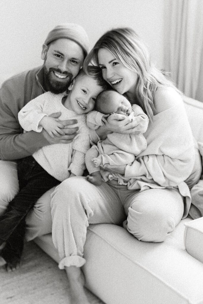 Entspannte Familie mit Baby, gemütlich auf dem Sofa beim Baby-Fotoshooting in Hohberg.