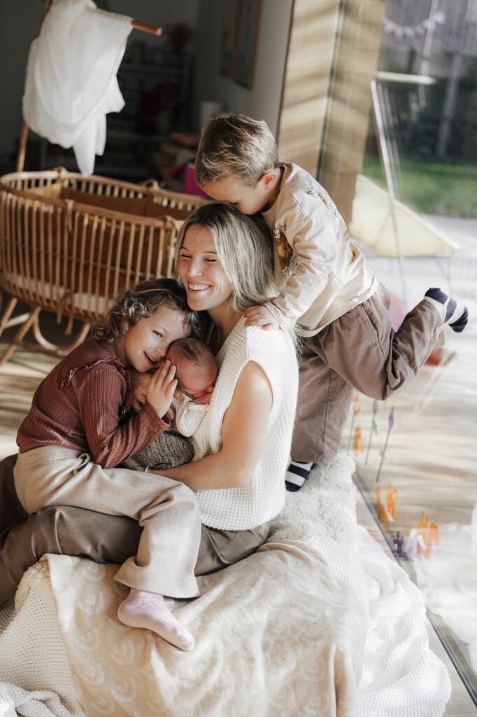 Glückliche Mama mit ihren Kindern und Baby auf dem Arm bei einer Homestory in Oberkirch.