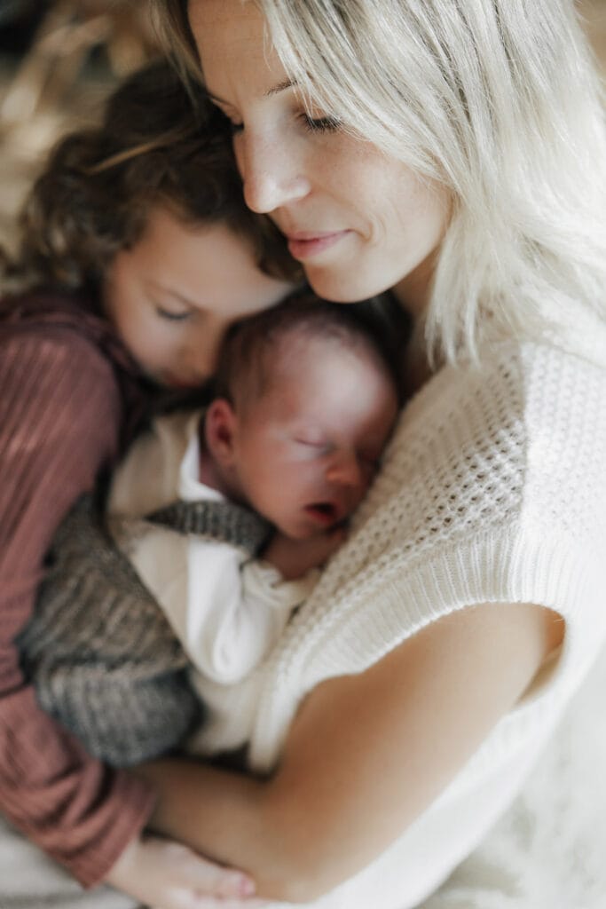 Mama umarmt liebevoll ihr Baby und Tochter für erste Familien-Erinnerungen in Oberkirch.