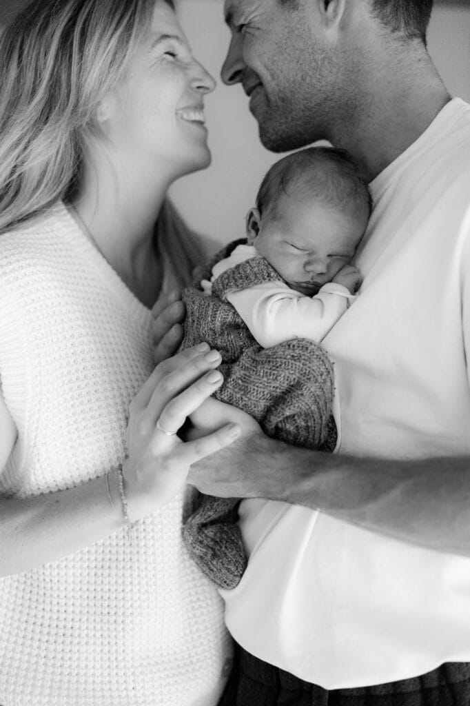 Glückliche Eltern mit Baby im Arm bei einem Neugeborenen-Fotoshooting in Oberkirch.