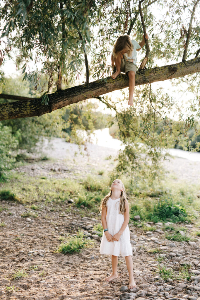 Kinder spielen auf einem Baum bei der Kinzig in Offenburg.